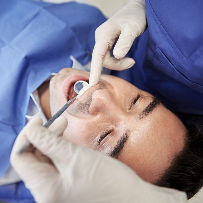 A man having his teeth examined